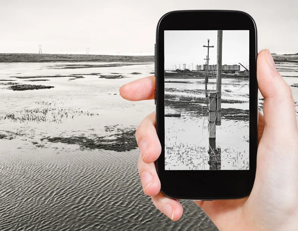 Tourist taking photo of melted snow in tundra