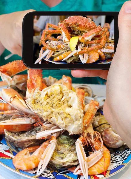 Tourist photographs of seafood plate with crab, prawns, shrimps