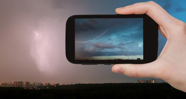 Tourist photographs of lightning bolt over city