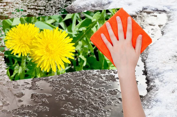 Hand deletes melting snow by orange cloth