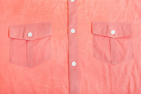 Pockets and buttons of red shirt close up