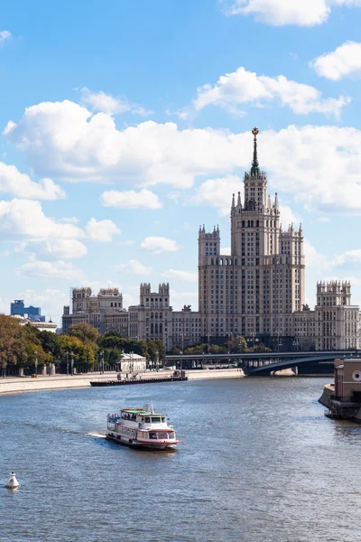 Boat in Moskva river and tall building in Moscow