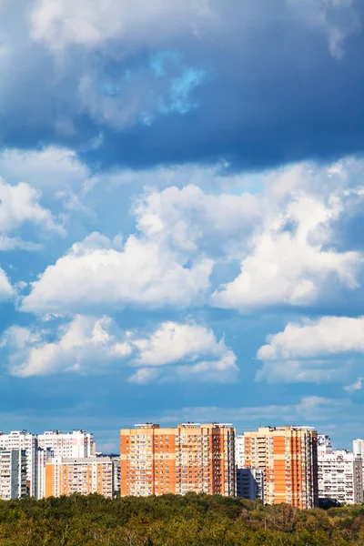 Blue and white low clouds over apartment buildings