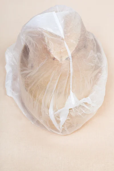 Wooden hat-block wrapped in plastic wrap