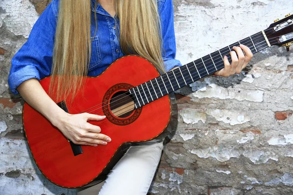 Women\'s hands playing the guitar