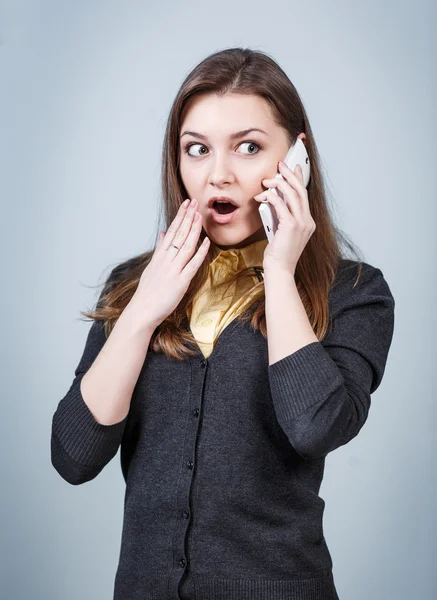 Surprised woman speaks on the phone