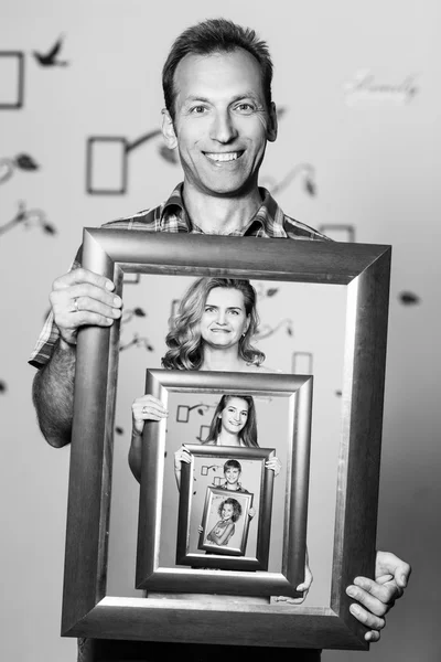 Happy father holding portrait with his family