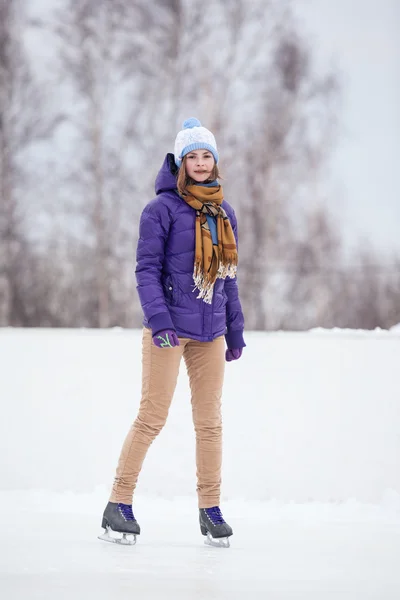 Young woman skating on ice with figure skates