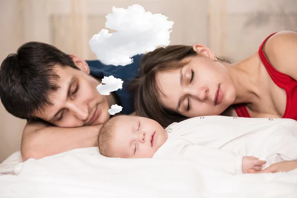 Baby sleeps  with tired parents