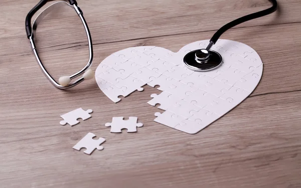 Stethoscope on puzzle, solving the mystery of health care