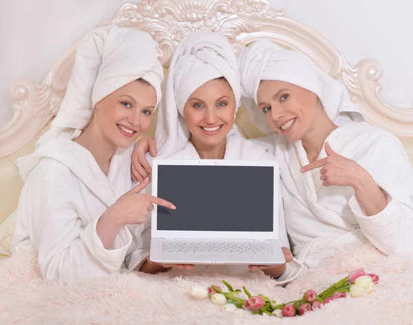 Women wearing a white bathrobes with laptop