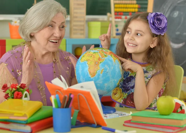 Girl making homework with granny