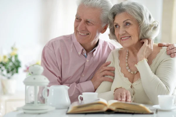 Senior couple drinking tea  with book