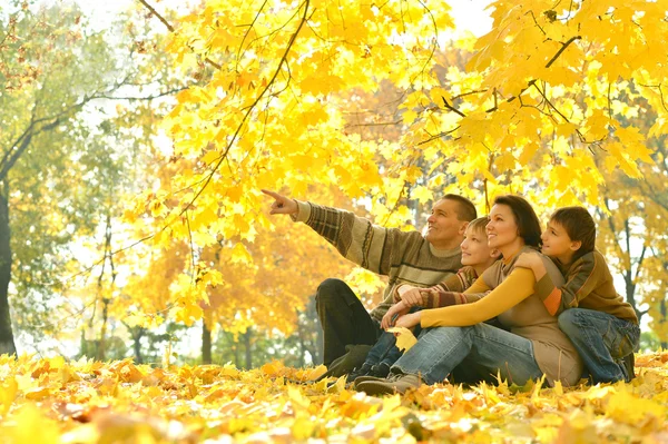 Family sitting in autumn park