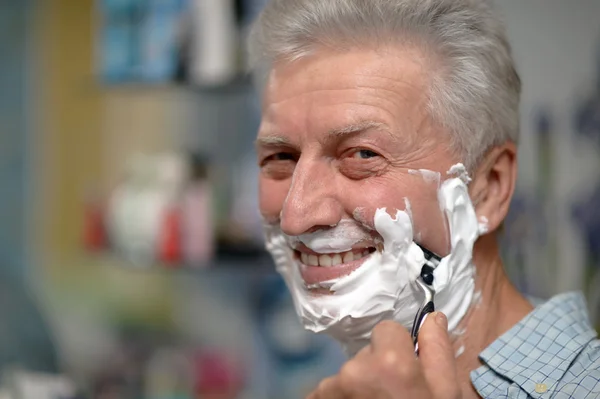 Senior man shaving