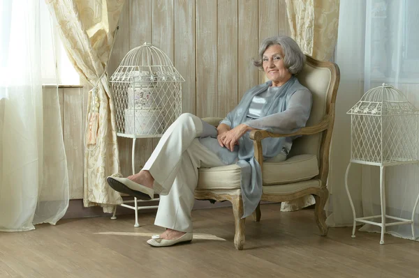 Elderly woman on chair in vintage room