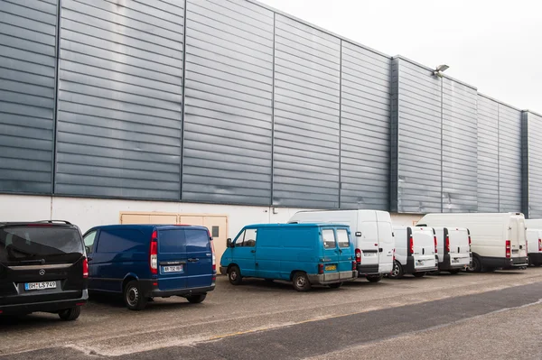Diverse vans parked near industrial cargo dispatch building