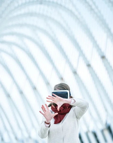 Woman wearing a virtual reality headset, controlling the experie
