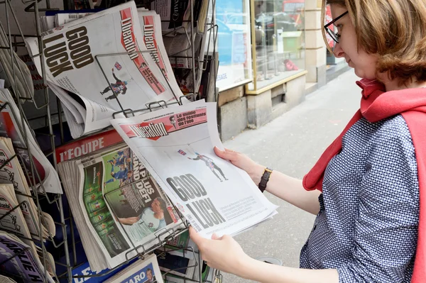 Woman buying LIBERATION newspaper with shocking headline about
