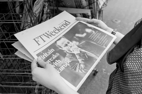 Woman buying FT Weekend newspaper with shocking headline about