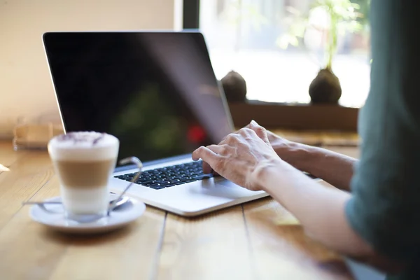 Green shirt woman typing blank screen laptop