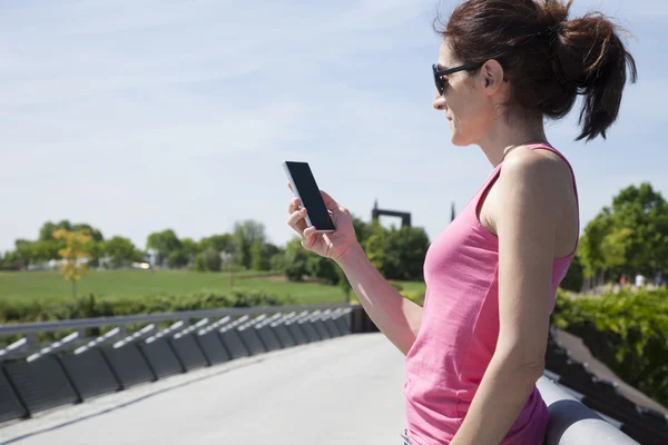 Woman reading phone in park