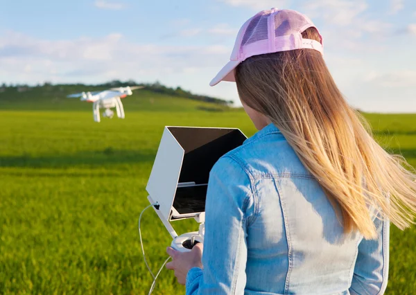 Woman with radio controller and flying drone