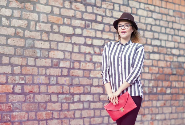 Young attractive student woman wearing hat and glasses holding a bag