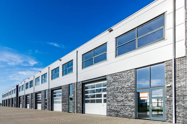 Modern industrial building with loading doors and blue sky