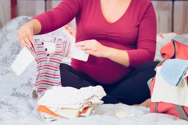 Pregnant woman packing hospital bag preparing for labor