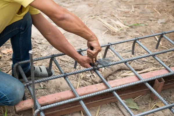 Workers are preparing steel poles for building house