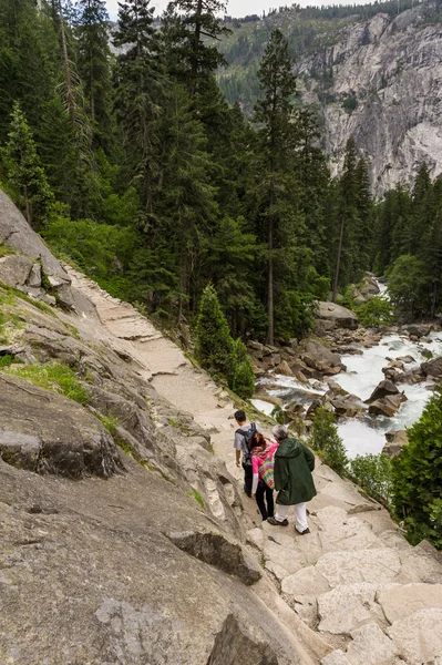 Tourists climbing down steep cliff