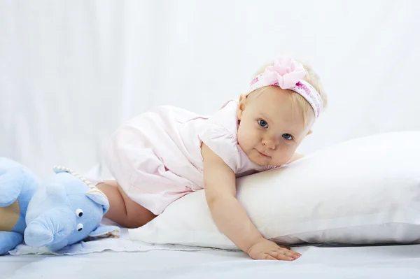 Baby is playing with pillow over white background