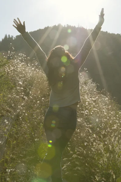 Woman spread her arms to the side enjoying the sun