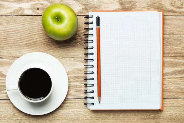 Notepad with coffee , apple and pencil