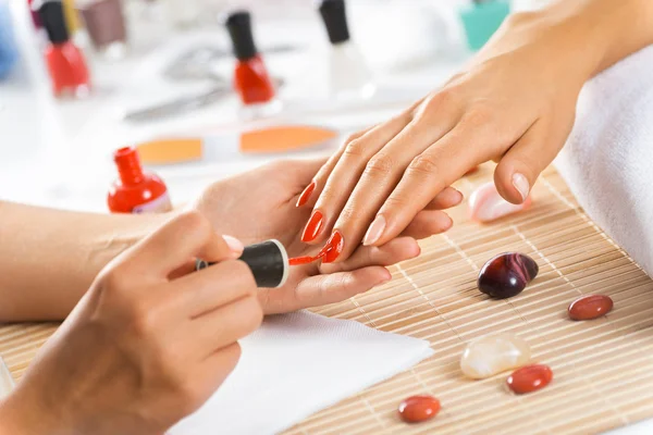 Woman in salon receiving manicure