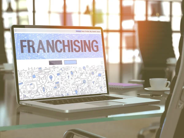 Franchising on Laptop in Modern Workplace Background.