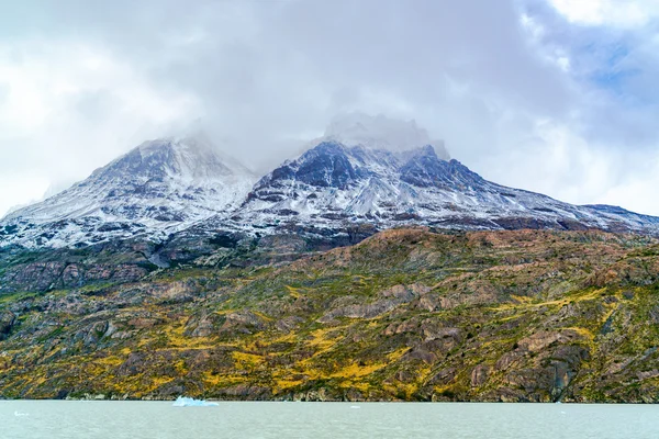 View of ice mountain and river with ice floating in the water