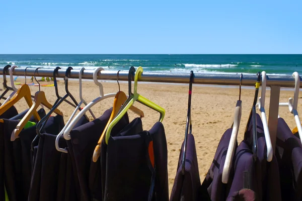 Surfing wet suits on hangers drying