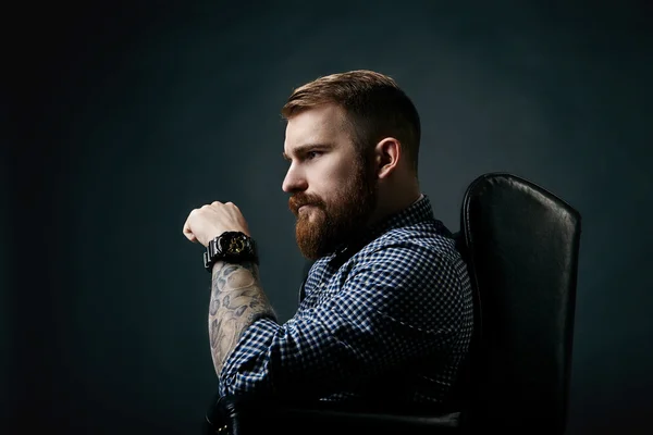 Thoughtful red bearded man studio portrait on dark background
