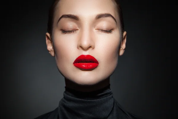Close-up of sensual model with red lips and eyes closed