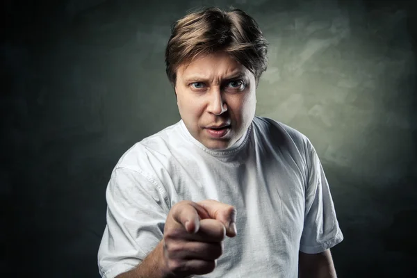 Portrait of angry young man pointing at you