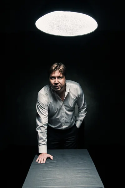 Man in dark room illuminated by lamp