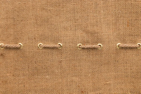 Burlap with one lines of rope and gold rings