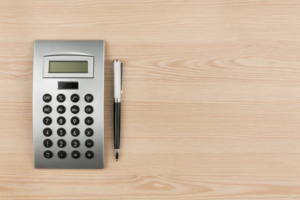 Close-up of luxury black pen and calculator on wooden desk