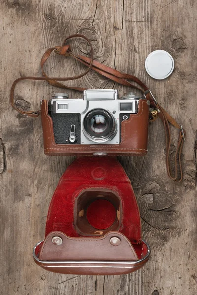 Retro camera in leather case on wooden background