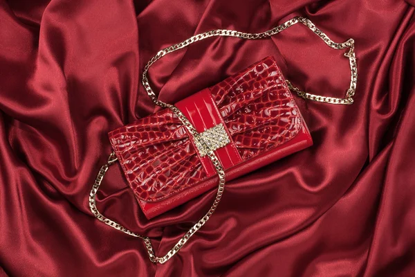 Red lacquer bag lying on a red silk