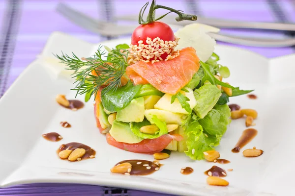 Round shaped Smocked salmon salad with avocado decorated with ch