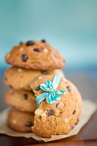 Stacked chocolate chip cookies with small blue ribbon
