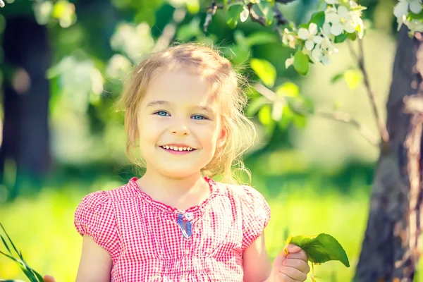 Happy little girl in spring sunny park